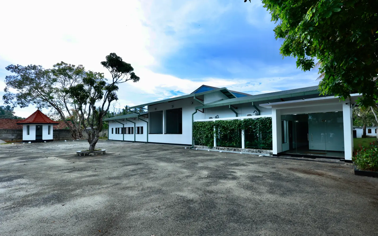 White SDS facility building with a glass entrance and landscaped courtyard