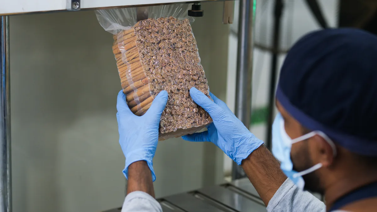 SDS team member handling a vacuum-packed bundle of Ceylon cinnamon quills