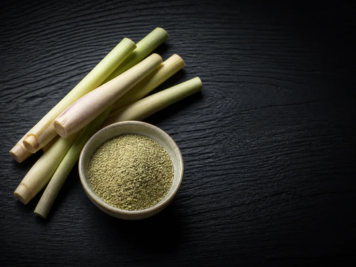 Lemon grass stalks and powder on dark wood